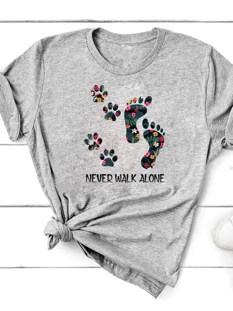 Short Sleeve T-Shirt for Women with colorful paw prints and 'Never Walk Alone' text on gray fabric.