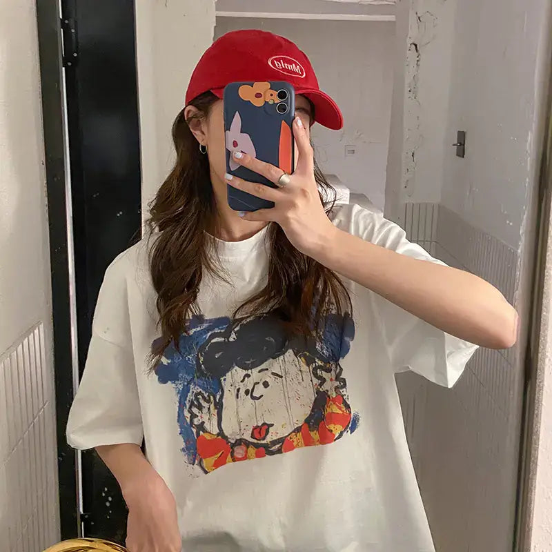 Short Sleeve T-Shirt for Women featuring a unique cartoon graphic design and worn with a red cap.