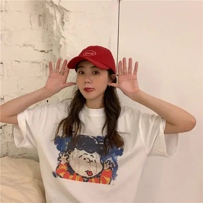 Short Sleeve T-Shirt for Women featuring a cartoon design, worn by a young woman with a red cap.