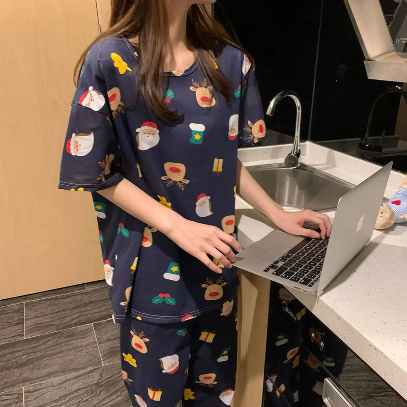 Woman in Fashion Cartoon Pajamas for Women, relaxing with a laptop in a modern kitchen.