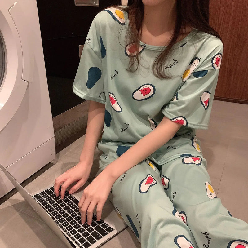 Woman wearing Fashion Cartoon Pajamas for Women while working on a laptop, showcasing comfort and casual style.