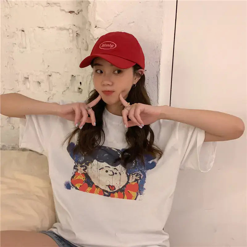 Short Sleeve T-Shirt for Women worn by a girl, featuring a cartoon print and paired with a red cap.