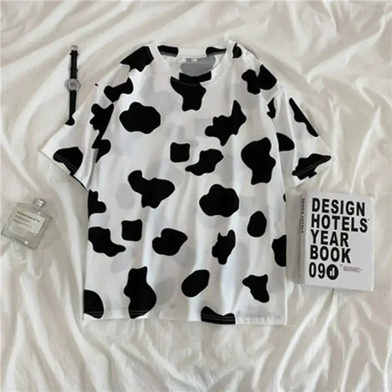 Short Sleeve T-Shirt For Women's in black and white cow print on a flat surface.